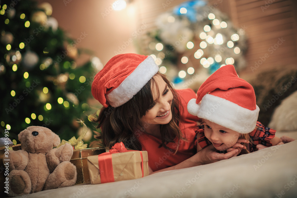 Happy family Mom with a daughter together on the background of Christmas decorations. Merry Christmas and Happy New Year!