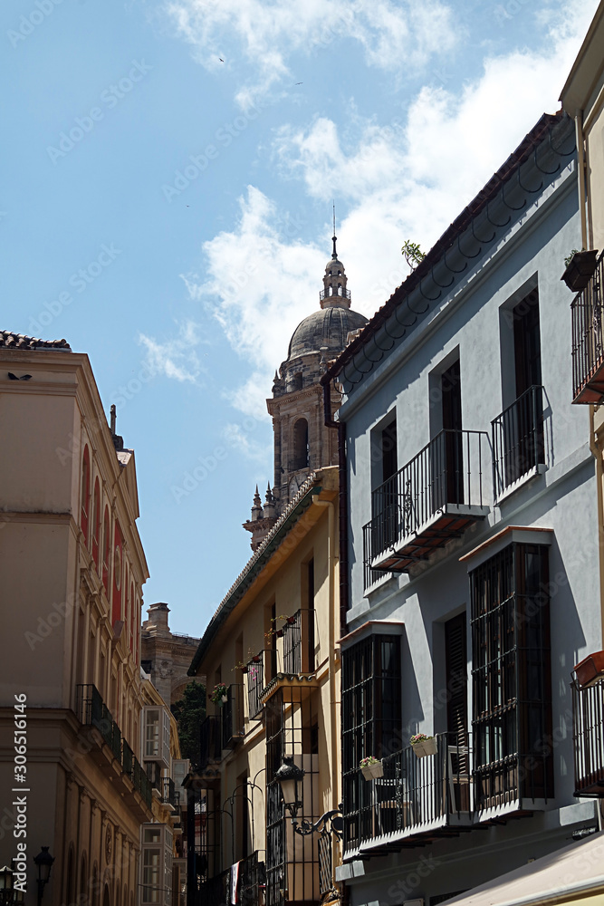Fototapeta premium Downtown Malaga. Medieval streets that lead to the main focus of the ancient city, the Cathedral. In the distance, above the rooftops, is the north tower of that fine building.