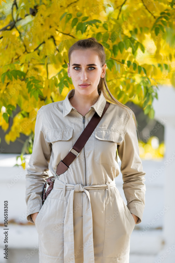 Fototapeta premium Three quarter length portrait of blonde person in a jumpsuit in public Park