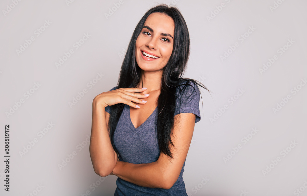 Sparkles of laughter. Close-up photo of a gorgeous girl with raven black hair, who is looking in the camera, smiling and holding her right hand near her chest. Sparkles of laughter. Close-up photo of a gorgeous girl with raven black hair, who is looking in the camera, smiling and holding her right hand near her chest.