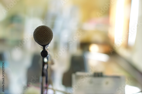 Close-up of microphone on stage against blur background.
