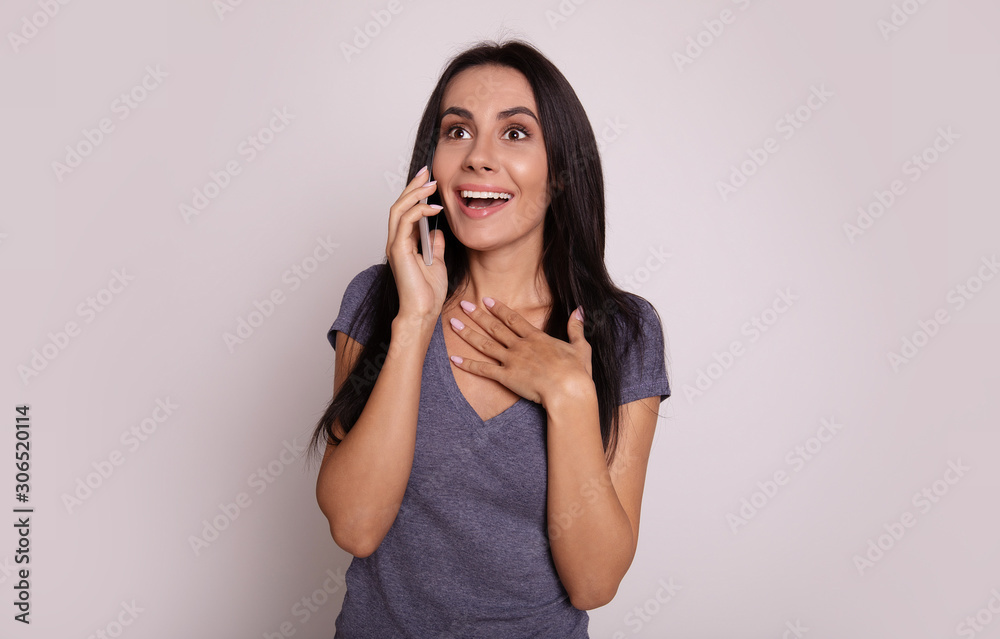 I’m so happy! Close-up photo of a beautiful woman talking on the phone and pressing her hand to her chest expressing surprise both with her gesture and with her face. I’m so happy! Close-up photo of a beautiful woman talking on the phone and pressing her hand to her chest expressing surprise both with her gesture and with her face.