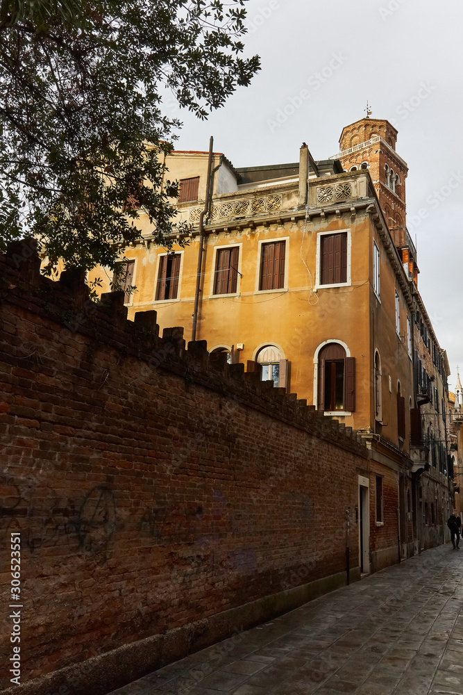 yellow house and a brick wall in san polo district in venice