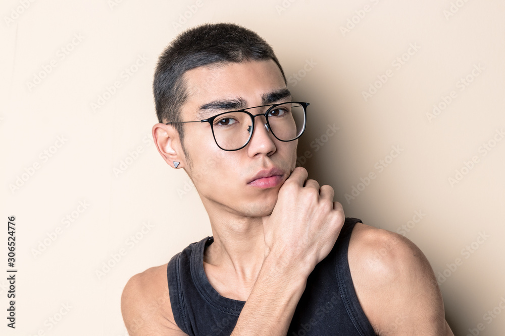 Young sexy man in glasses posing and looking at camera