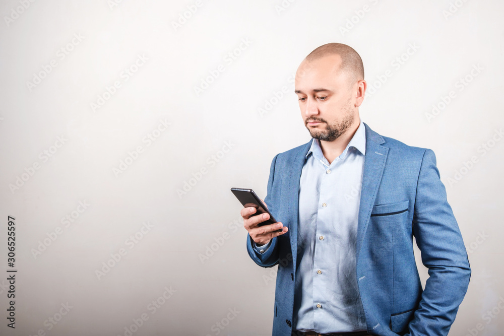 A business man in a jacket looks at the phone. The concept of remote work A business man in a jacket looks at the phone. The concept of remote work