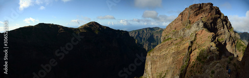 Wide panoramic view of Madeira island. Cliff and mountains with blue skies and clouds in background