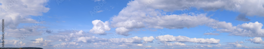 September is the autumn sky. White aerial clouds on a blue sky, panoramic photo. September is the autumn sky. White aerial clouds on a blue sky, panoramic photo.