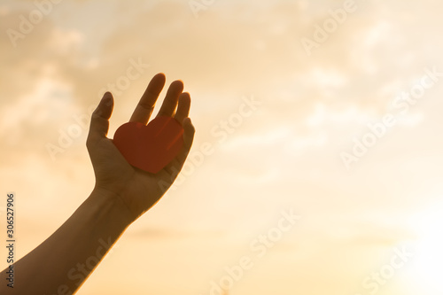 Silhouette broken heart,close up woman hand holding broken heart in the park.