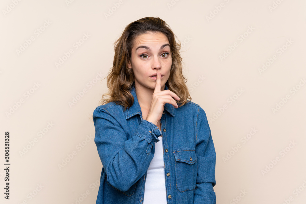 Young blonde woman over isolated background doing silence gesture Young blonde woman over isolated background doing silence gesture