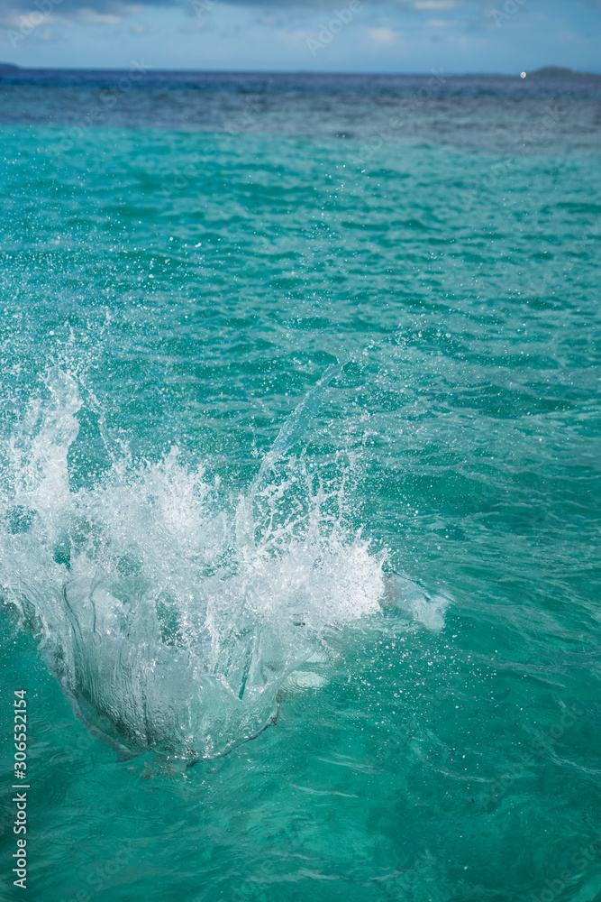 Fototapeta premium Huge splashing water in the sea from people falling into water, abstract art picture for background.