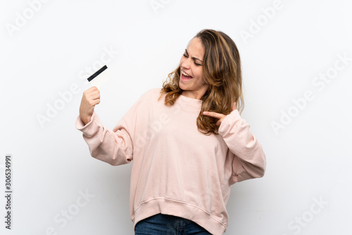 Young blonde woman holding a credit card