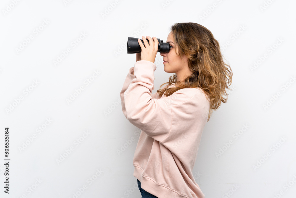 Young blonde woman with black binoculars Young blonde woman with black binoculars