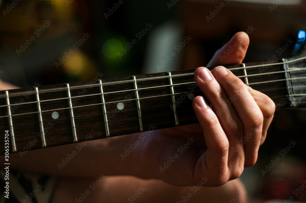 Close up guitarist tune up guitar strains. Close up guitarist tune up guitar strains.
