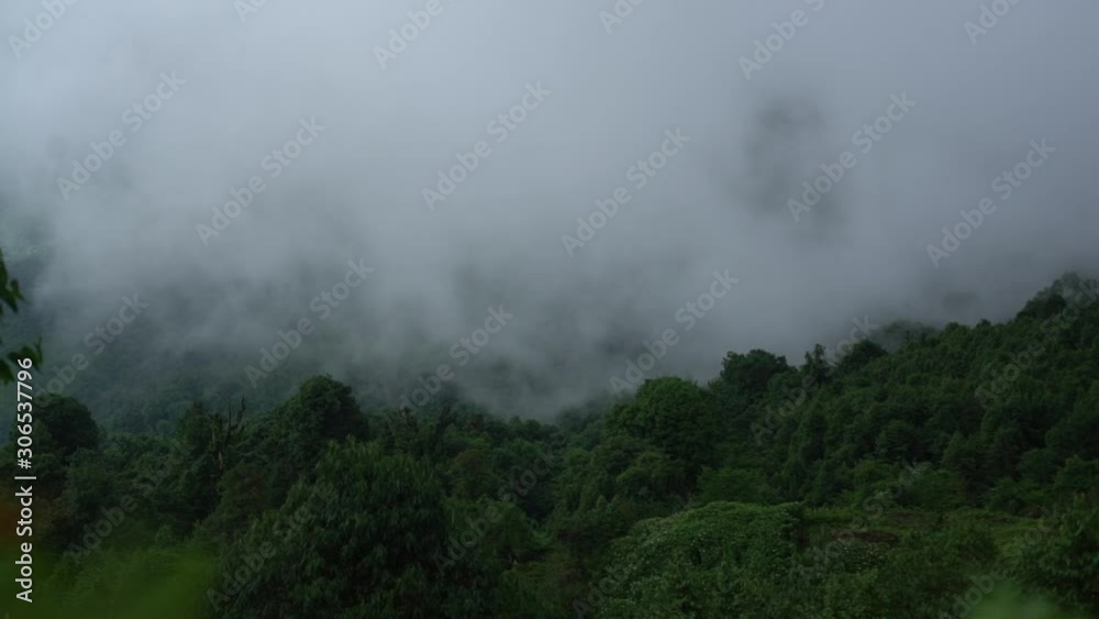 Day timelapse of Thick/dense fog movement over a jungle on a hill in Eastern Nepal. Wide Shot. Day timelapse of Thick/dense fog movement over a jungle on a hill in Eastern Nepal. Wide Shot.
