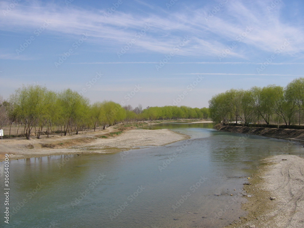 Spring sky over a shallow river and trees. View from the bridge on the river flowing away into the distance. Isfahan, Iran, 2007. Spring sky over a shallow river and trees. View from the bridge on the river flowing away into the distance. Isfahan, Iran, 2007.