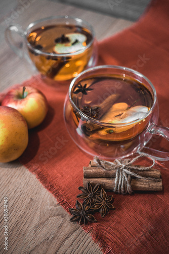 Apple Cider Drink, Juice, Punch, Tea with Spices, Cinnamon sticks, star anise and fresh Apples on a wooden background. Hot drink for Autumn and Winter evenings. Close up. Seasonal mulled drink.