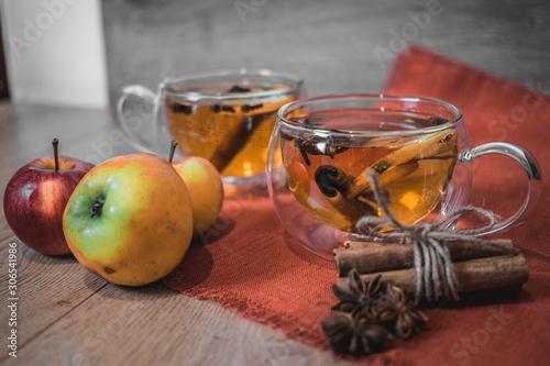 Apple Cider Drink, Juice, Punch, Tea with Spices, Cinnamon sticks, star anise and fresh Apples on a wooden background. Hot drink for Autumn and Winter evenings. Close up. Seasonal mulled drink.