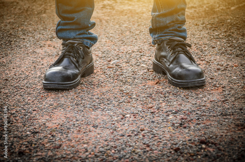 Man wearing safety shoes black color, standing on the ground