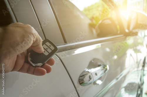 Photography Car remote control by smart key, Hand holding smart key to lock doors of white c