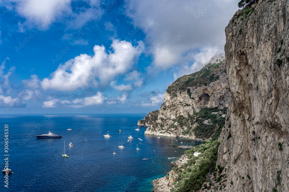 Crag cliff by Tyrrhenian sea in summer with dramatic couds, view from Garden of Augustus, Capri