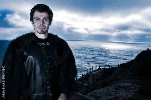 Foto Portrait of handsome knight with goatee and fur coat looking at camera with ocea
