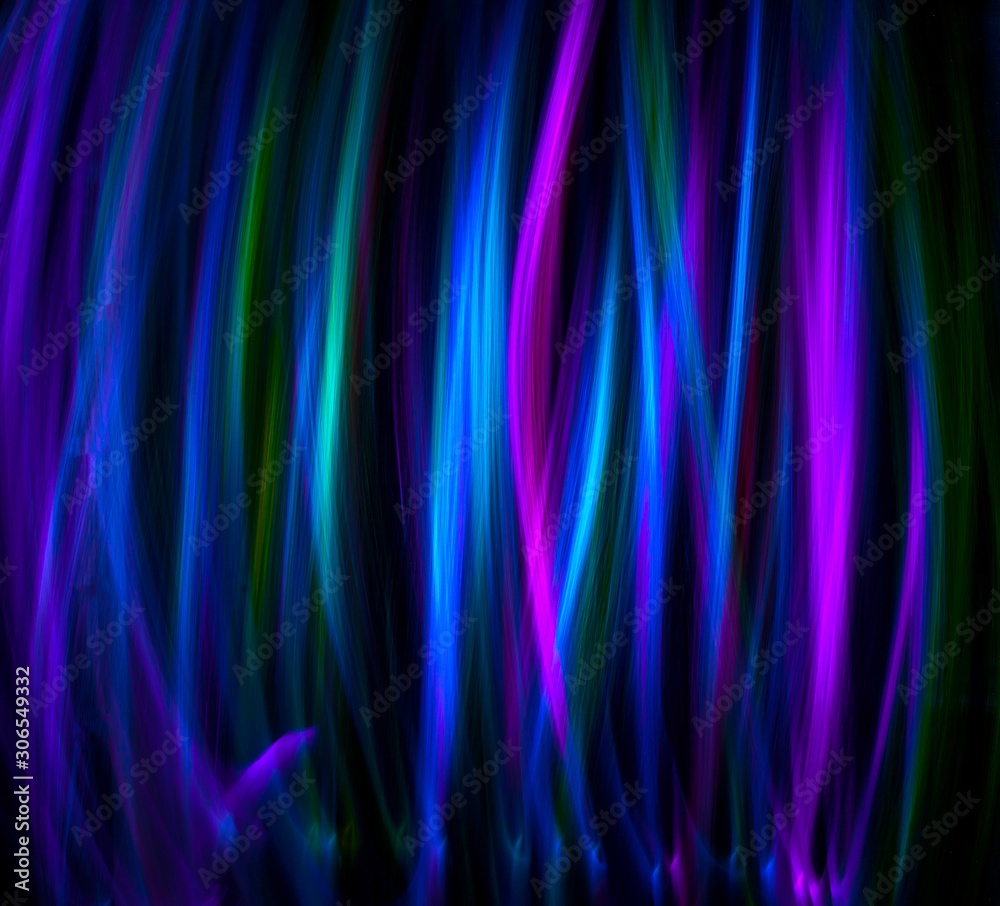Obraz premium Multi color light painting, long exposure photography, abstract vertical lines of color against a black background.