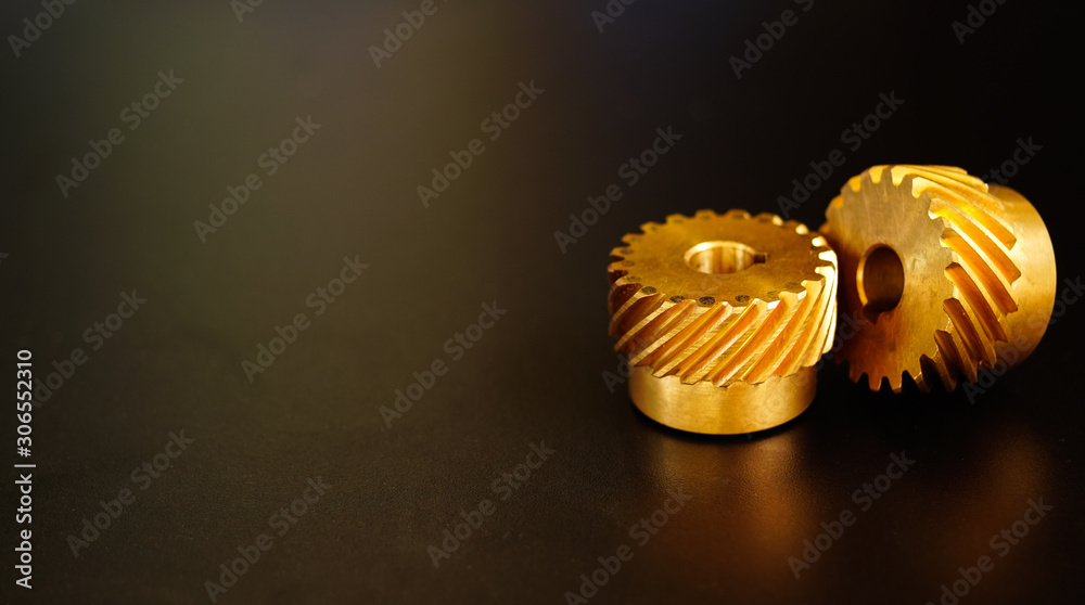 Helical Gears Brass on a black background , concept of work process movement gears Helical Gears Brass on a black background , concept of work process movement gears