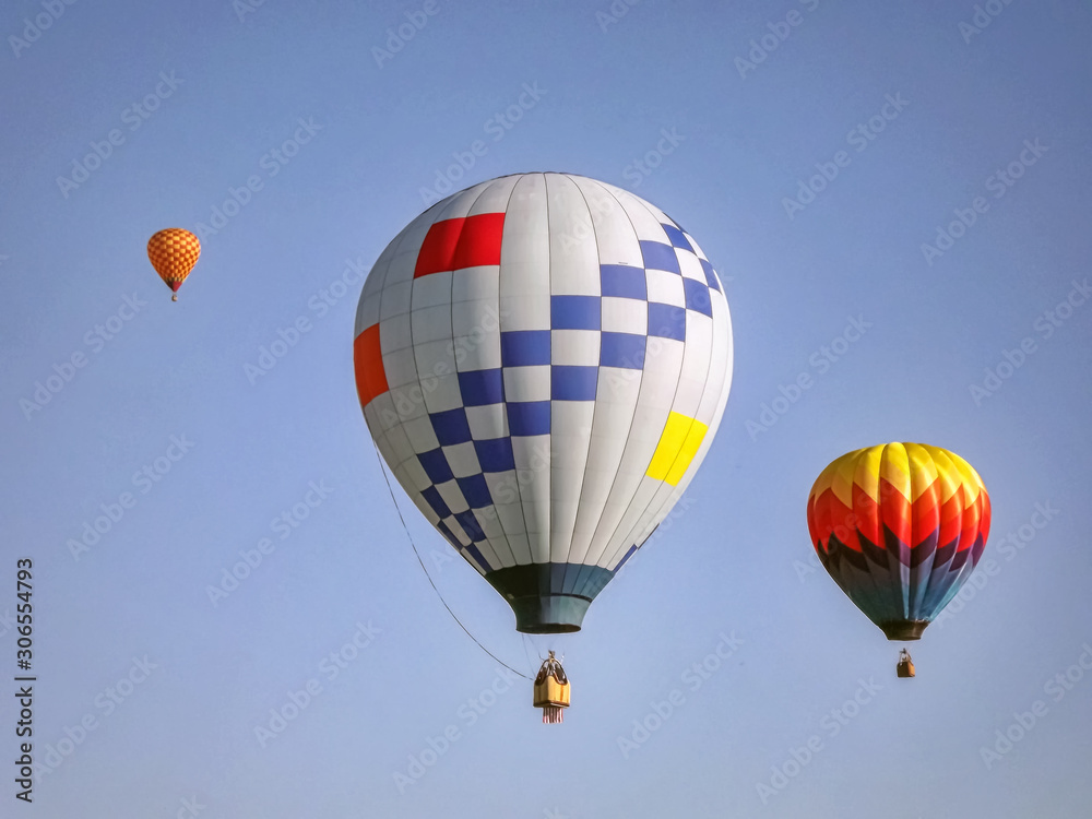Colorful hot air balloons in flight over a field Colorful hot air balloons in flight over a field