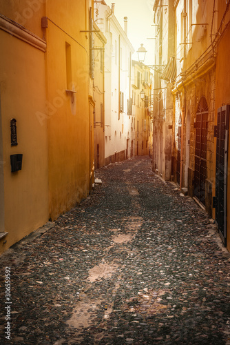 Sun shining over a narrow alley in old town Alghero