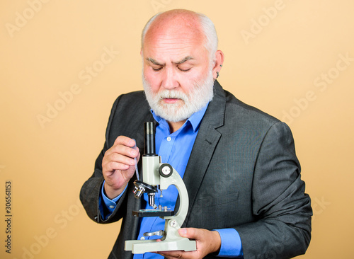 Doctoral work and postdoctoral employment. Biology experienced lecturer. Molecular biology PhD projects. Mature man formal suit with microscope. Professor university lecturer. Scientist microbiology photo