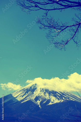 Background image of beautiful Fuji mountain with snow and clouds on top and cherry branch over sky  Japan