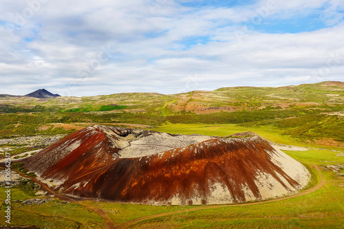 a small crater of a dormant volcano of Grábrók (Iceland); green meadows in the tundra, arctic summer