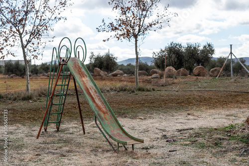 Tobogán viejo y oxidado en parque abandonado.