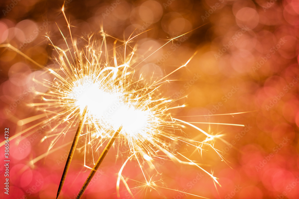 close-up of burning sparklers on beautiful bokeh background, christmas and new year festive concept