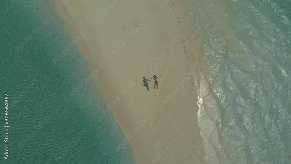 4K aerial top view of tropical sandbar. Aloha written made from starfishes on candaraman sandbar. drone turning around for romantic travel couple walking at sunset in Balabac, Palawan, Philippines 4K aerial top view of tropical sandbar. Aloha written made from starfishes on candaraman sandbar. drone turning around for romantic travel couple walking at sunset in Balabac, Palawan, Philippines