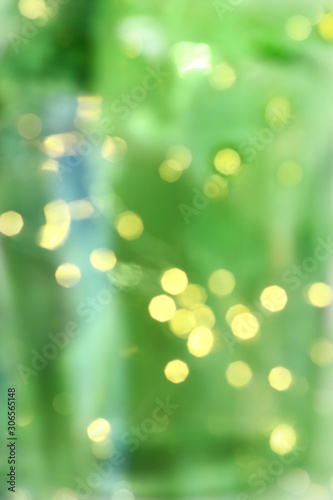 yellow blurry lights of garlands on a green background. soft christmas tree holiday light