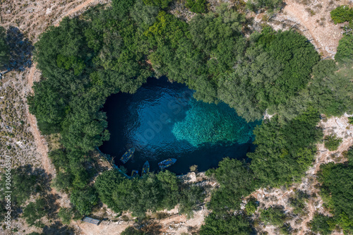 Aerial overhead drone shot of tourists boat in subterranean Melissani Lake Cave in Kefalonia Island