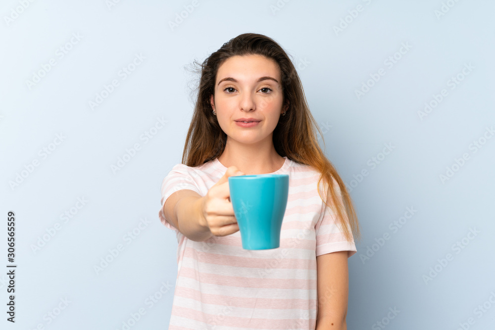 Young brunette girl holding a cup of coffee over isolated background Young brunette girl holding a cup of coffee over isolated background