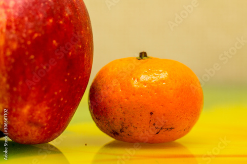 Tangerine near Apple. Photo. Background.