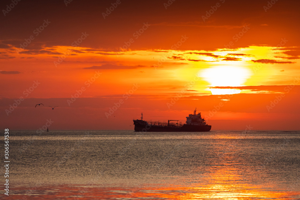 Silhouetted ship and flying seagulls at sunrise. Silhouetted ship and flying seagulls at sunrise.