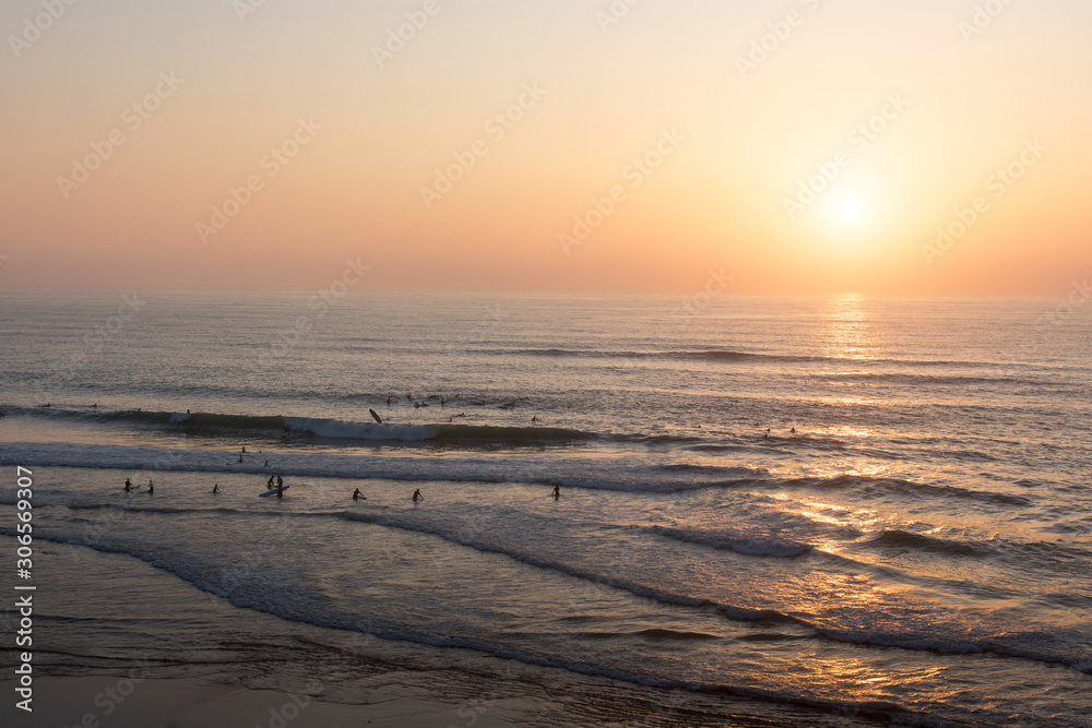 Foto de puesta de sol playa con surfistas