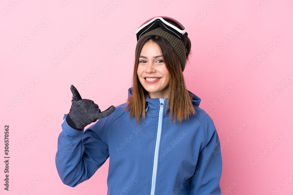 Young skier woman over isolated pink background making phone gesture