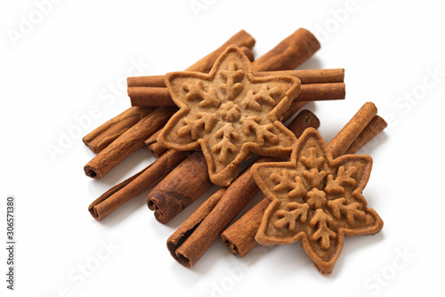 Cinnamon sticks with christmas cookies on white backgroun