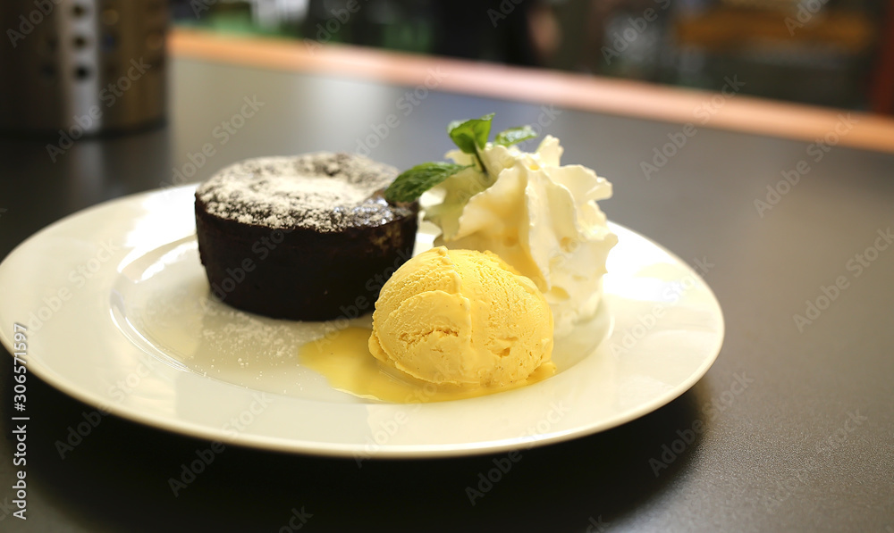 Hot chocolate fondant with ice cream and cream on a plate Hot chocolate fondant with ice cream and cream on a plate