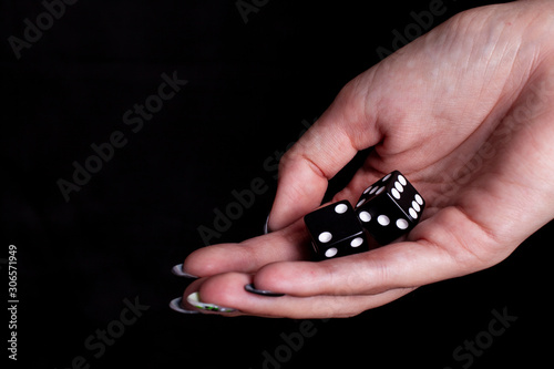 dices in the female hand with black background