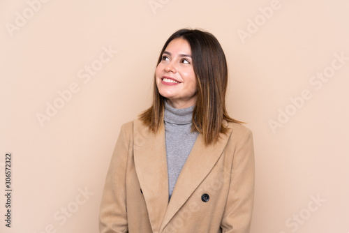 Young woman over isolated background laughing and looking up