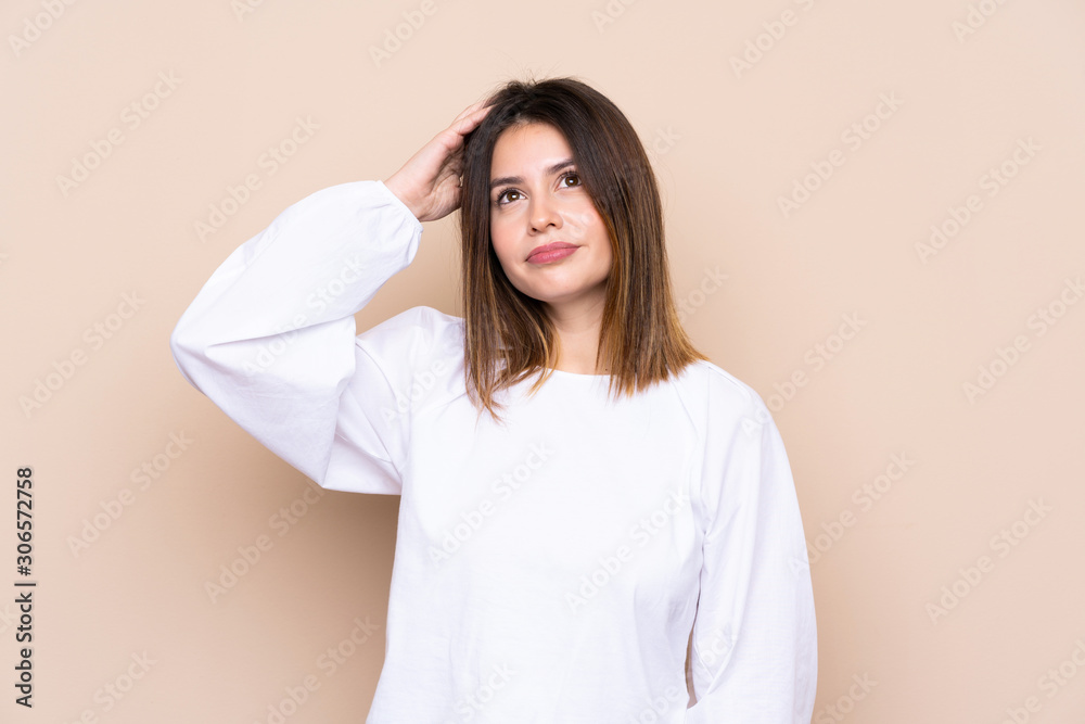 Young woman over isolated background having doubts and with confuse face expression Young woman over isolated background having doubts and with confuse face expression