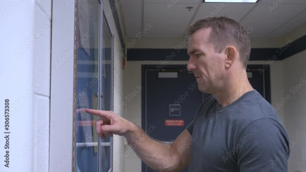 Man checking bulletin board for class room schedule. Man checking bulletin board for class room schedule.