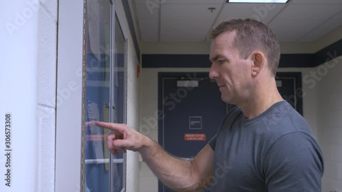 Man checking bulletin board for class room schedule.