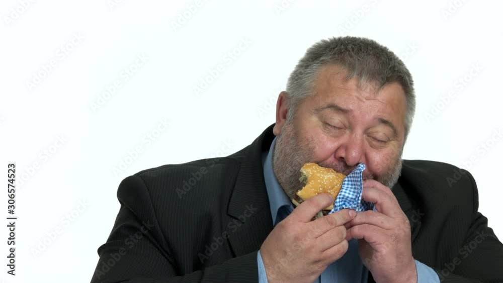 Close up overweight businessman enjoying hamburger. Unhealthy snack at office. Junk food lead to health problem. Close up overweight businessman enjoying hamburger. Unhealthy snack at office. Junk food lead to health problem.